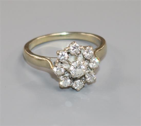 A white metal and diamond cluster flower head ring, size X.